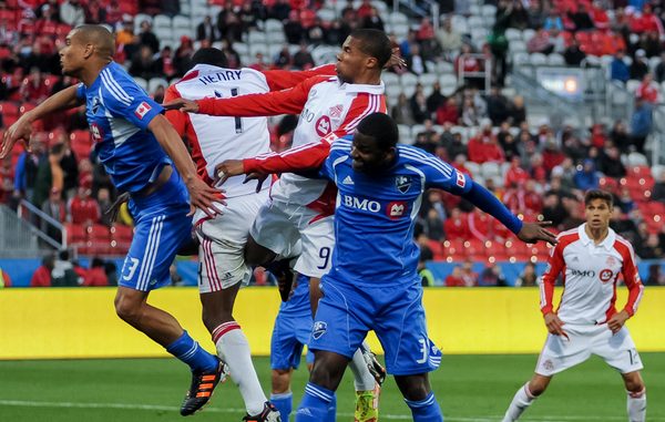 Toronto FC's Ryan Johnson (centre) wins the battle for a header against teammate Doneil Henry and Montreal Impact's Matteo Ferrari (left) and Shavar Thomas (right). TFC won 2-0 against the Impact on Wednesday night at BMO Field (Karan Vyas)